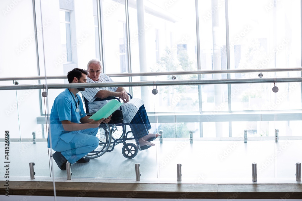 Doctor interacting with male senior patient in passageway Doctor interacting with male senior patient in passageway