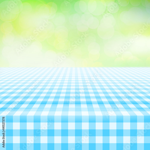 Empty picnic table, covered with checkered gingham tablecloth. Blurred green background. Summer picnic background for product presentation Vector illustration. Blue gingham pattern,