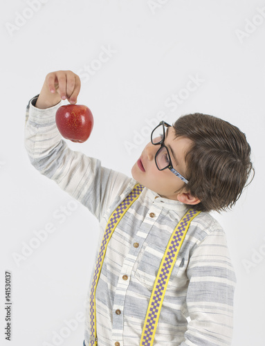 Niño con gafas mirando manzana  photo