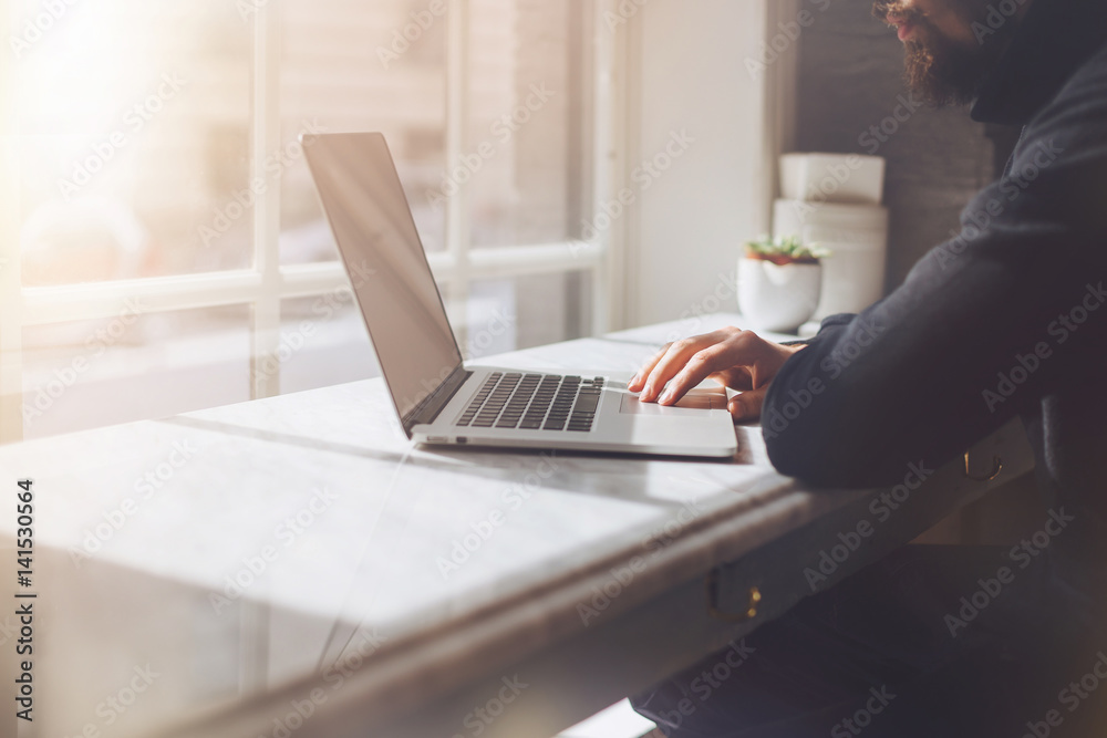 Fototapeta premium Young professional businessman wearing black turtleneck and using modern laptop, Close-up of female hands typing on notebook compute