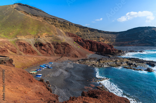 Beach with fishing boats on shore in El Golfo area, Lanzarote, Canary Islands, Spain