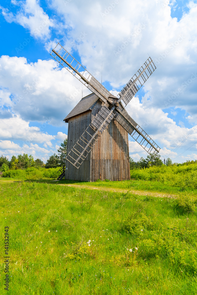Old wooden windmill on green field in spring landscape of Tokarnia village, Poland Old wooden windmill on green field in spring landscape of Tokarnia village, Poland