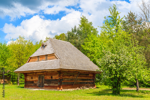 Old traditional house with straw roof in Tokarnia village on sunny spring day, Poland