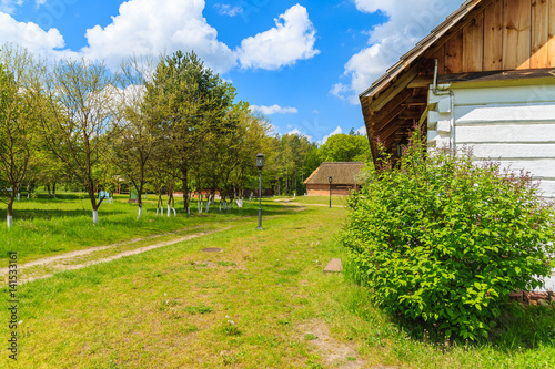Wallpaper Mural Rural road and old traditional house with straw roof in Tokarnia village on sunny spring day, Poland Torontodigital.ca