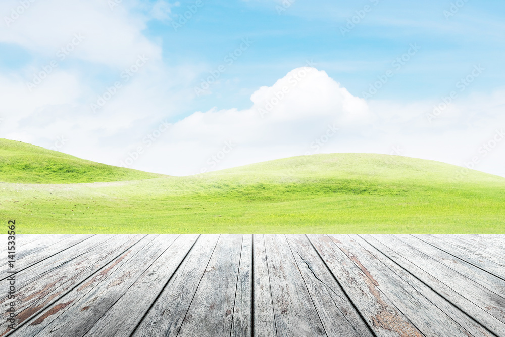 Wood table top on mound slope green grass natural background