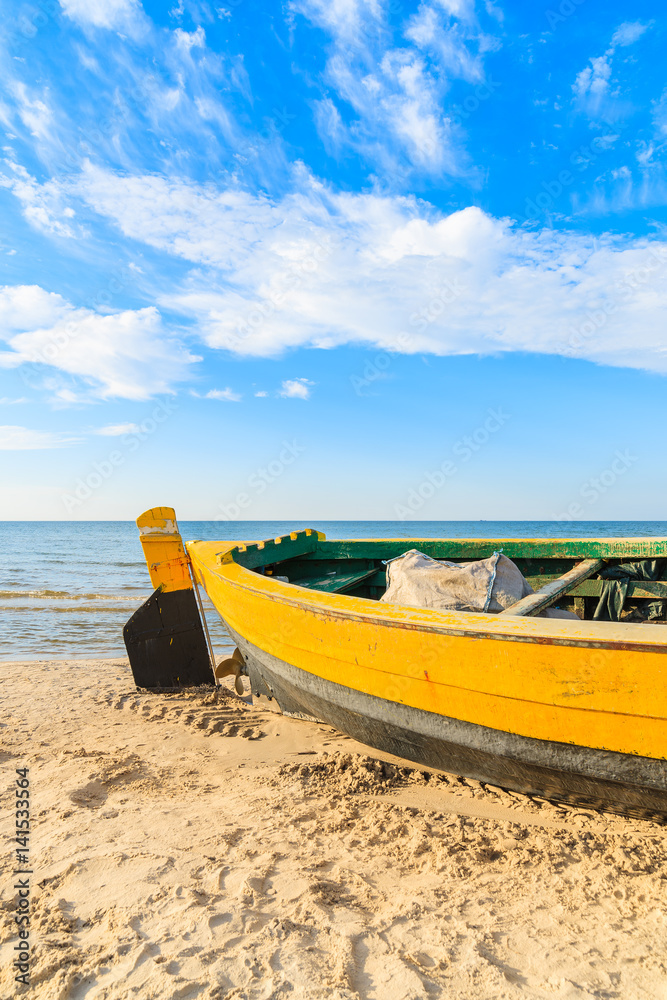 Colorful fishing boat on sandy Debki beach during sunny summer day, Baltic Sea, Poland