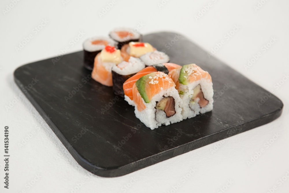 Maki, uramaki and nigiri sushi served in black stone slate Maki, uramaki and nigiri sushi served in black stone slate