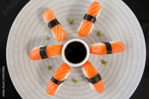 Nigiri sushi served with soy sauce in white plate