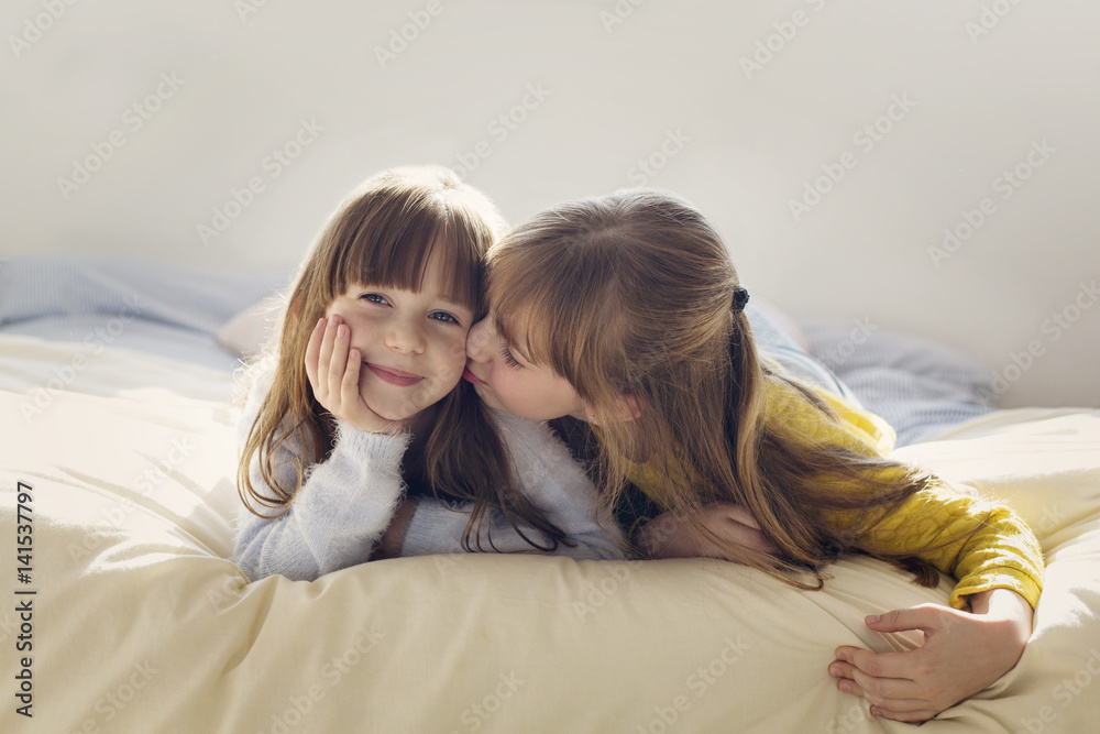 Two girls lying on bed Two girls lying on bed