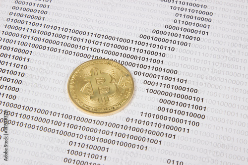 gold bitcoin on the background of binary code