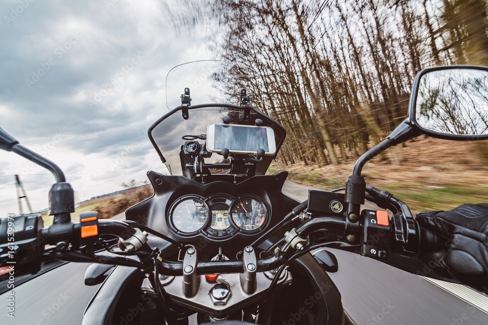 Naklejka premium Jazda motocyklem na wiosnę przy drodze asfaltowej