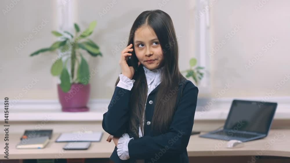 The little businessgirl communicates by phone The little businessgirl communicates by phone
