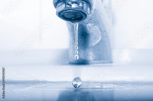 Faucet and falling water drops closeup