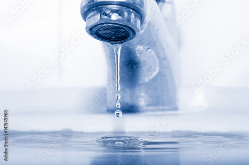 Water tap and falling drops closeup