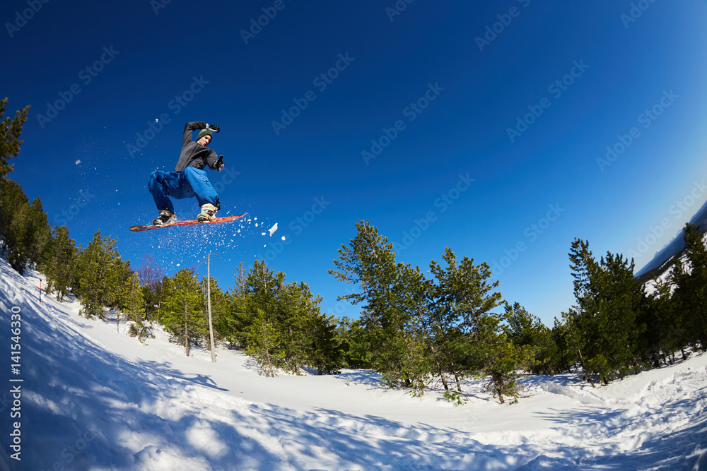 Flying snowboarder in the mountains
