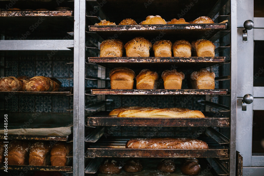 A lot of readymade fresh bread in a bakery oven in a bakery. Bread