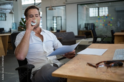 Businessman having coffee at desk © WavebreakMediaMicro