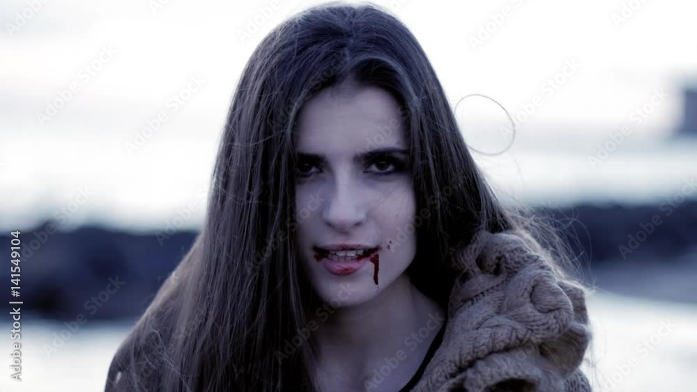 Scary female vampire smiling happy looking camera slow motion