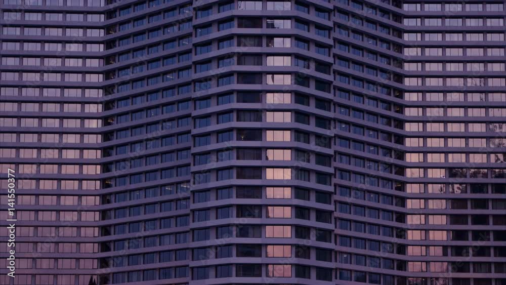 4k: Dusk to night. Nighttime time lapse of illuminated building windows at night .