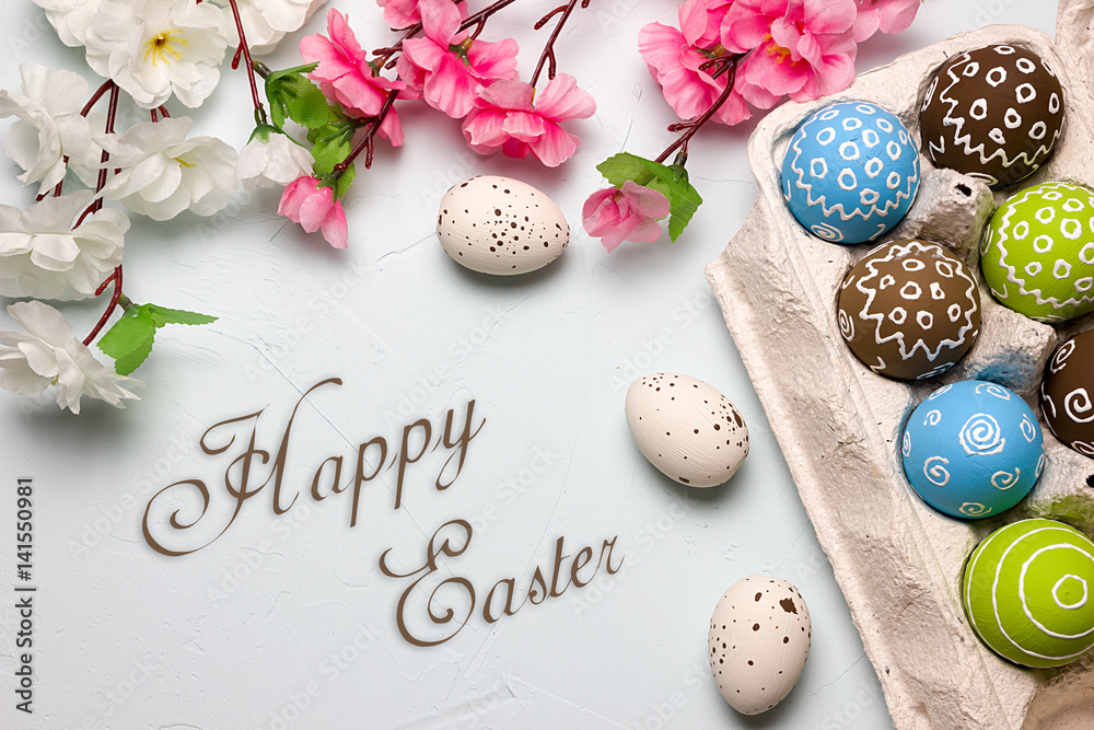 Painted easter eggs and branches of spring sakura closeup on a light blue background with space for congratulation Painted easter eggs and branches of spring sakura closeup on a light blue background with space for congratulation