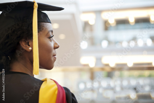 Woman in graduation gown looking away photo