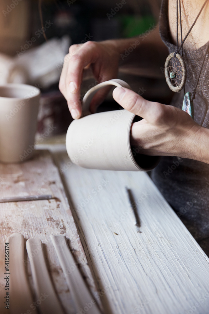 Young potter in workshop, close-up Young potter in workshop, close-up