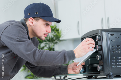 young repairman installing appliances at clients home