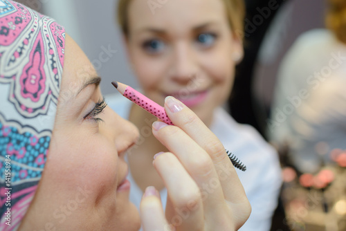 Beautician doing woman's eyebrows photo