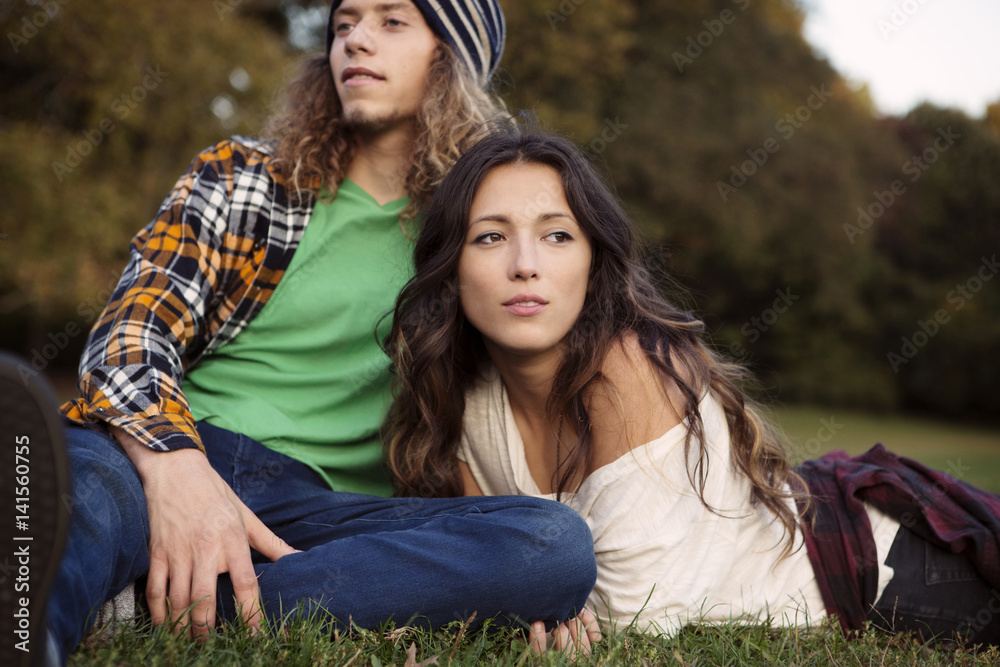 Low angle view of young couple relaxing in park Low angle view of young couple relaxing in park