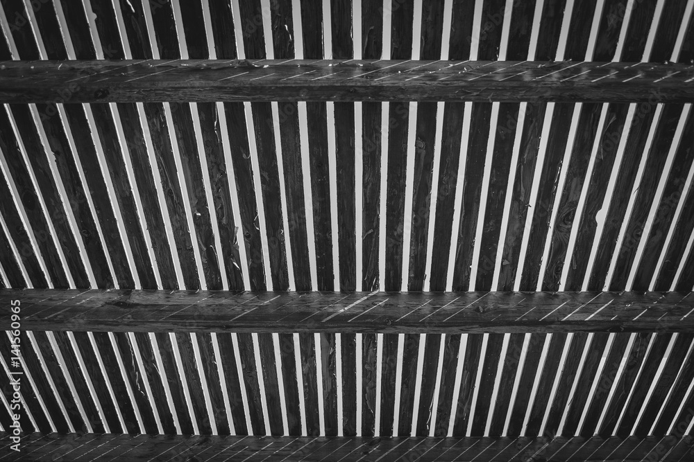 Board, ceiling background. Wooden roof with beams. Abstract architecture background, wooden interior construction, ceiling made of rough boards with light outside Board, ceiling background. Wooden roof with beams. Abstract architecture background, wooden interior construction, ceiling made of rough boards with light outside