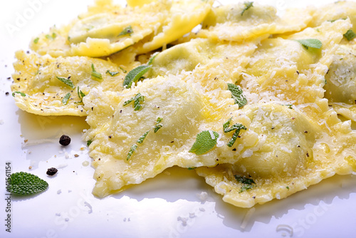 Homemade spinach and ricotta ravioli with sage butter sauce, parmesan and pepper