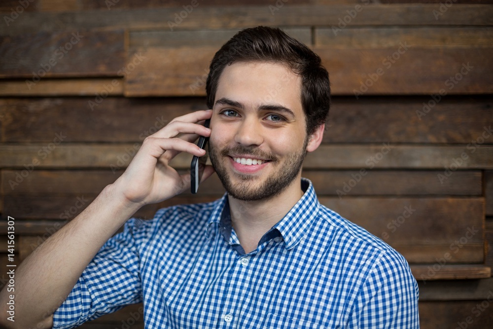 Smiling business executive talking on mobile phone in office Smiling business executive talking on mobile phone in office