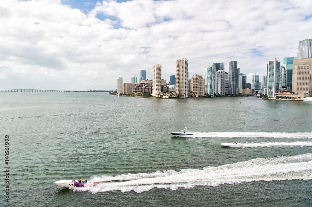 Obraz premium Aerial view of Miami skyscrapers with blue cloudy sky, boat sail