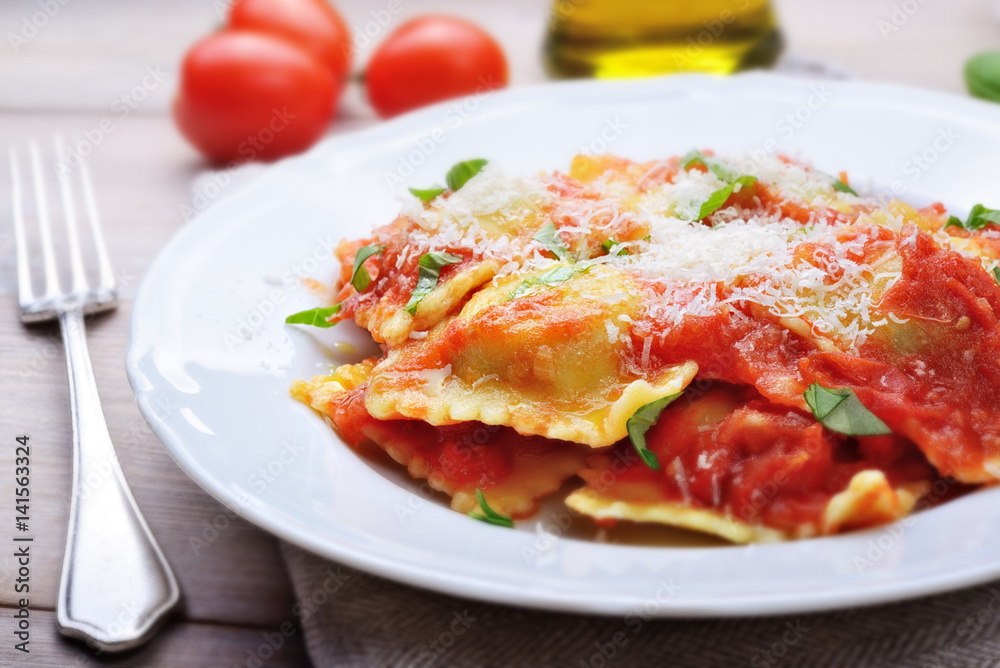 Spinach and ricotta ravioli with tomato sauce and parmesan Spinach and ricotta ravioli with tomato sauce and parmesan