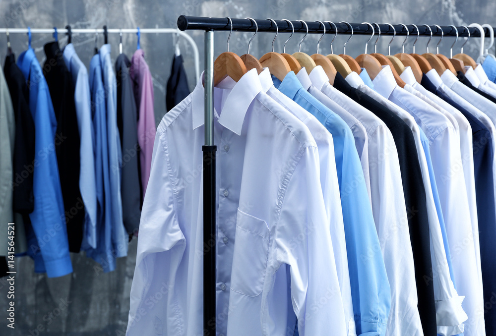 Rack of clean clothes hanging on hangers at dry-cleaning Stock Photo