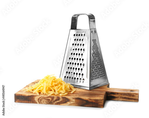 Wooden board with metal grater and cheese isolated on white