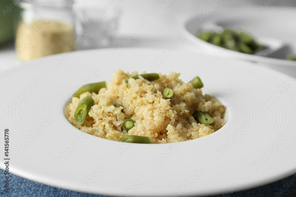 Cooked quinoa with French beans on white plate