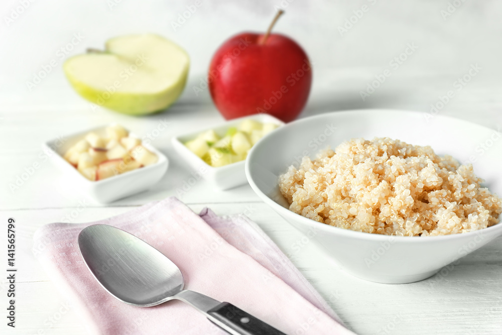 Bowl with cooked quinoa on kitchen table