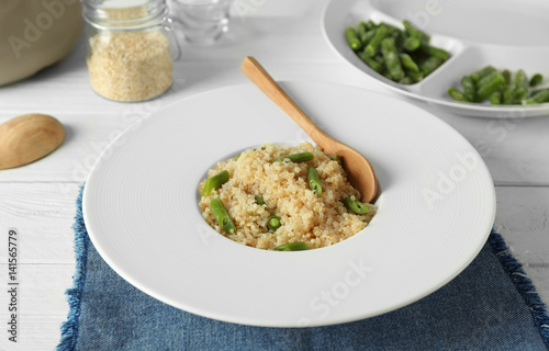 Cooked quinoa with French beans on white plate