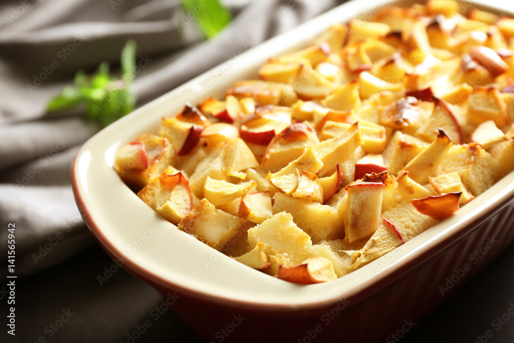 Tasty bread pudding with apples in baking dish on table Tasty bread pudding with apples in baking dish on table