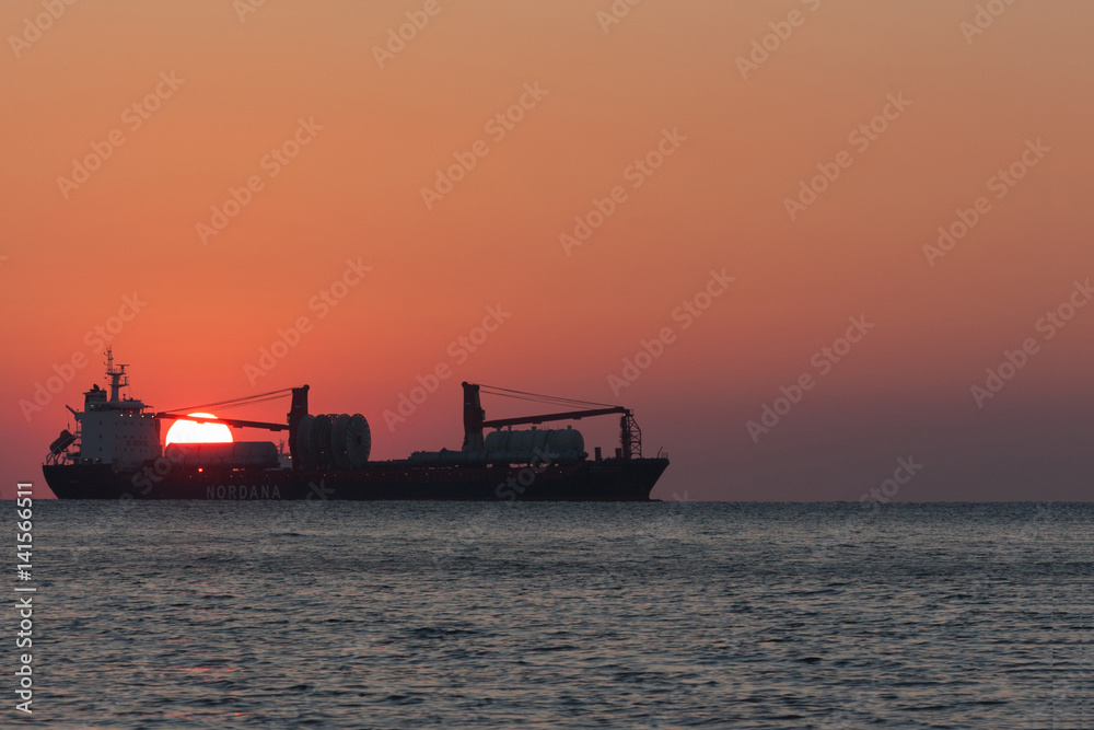 Ship on sunset background
