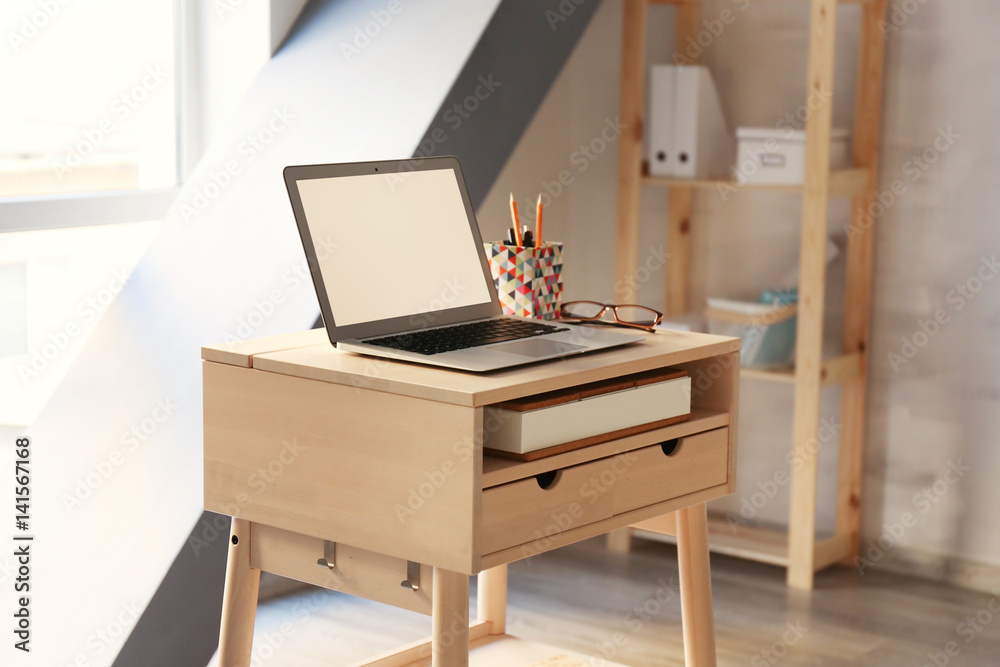 Stand-up desk with laptop in room Stand-up desk with laptop in room