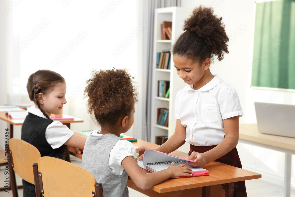 Beautiful elementary schoolgirls studying in classroom