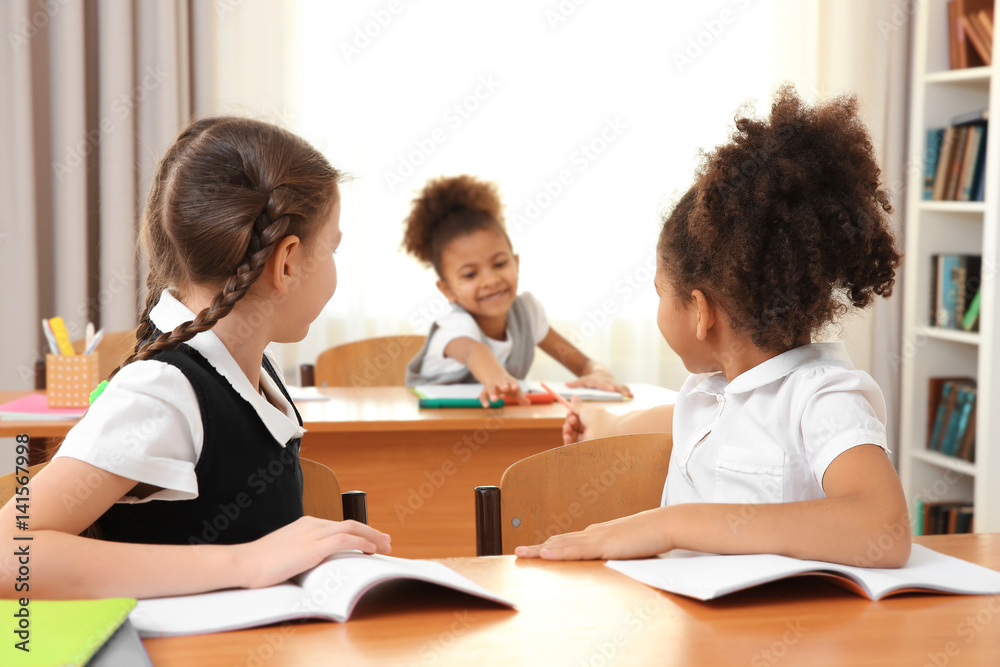 Beautiful elementary schoolgirls studying in classroom Beautiful elementary schoolgirls studying in classroom
