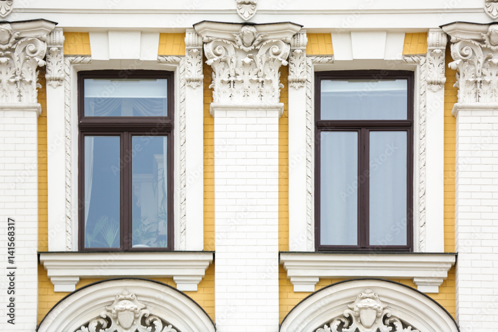 Fototapeta premium Ornate building with vintage windows and brick wall background