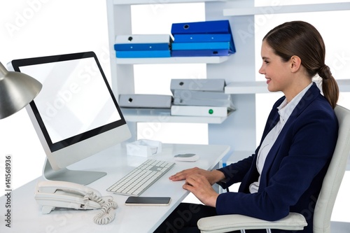 Smiling businesswoman working on computer