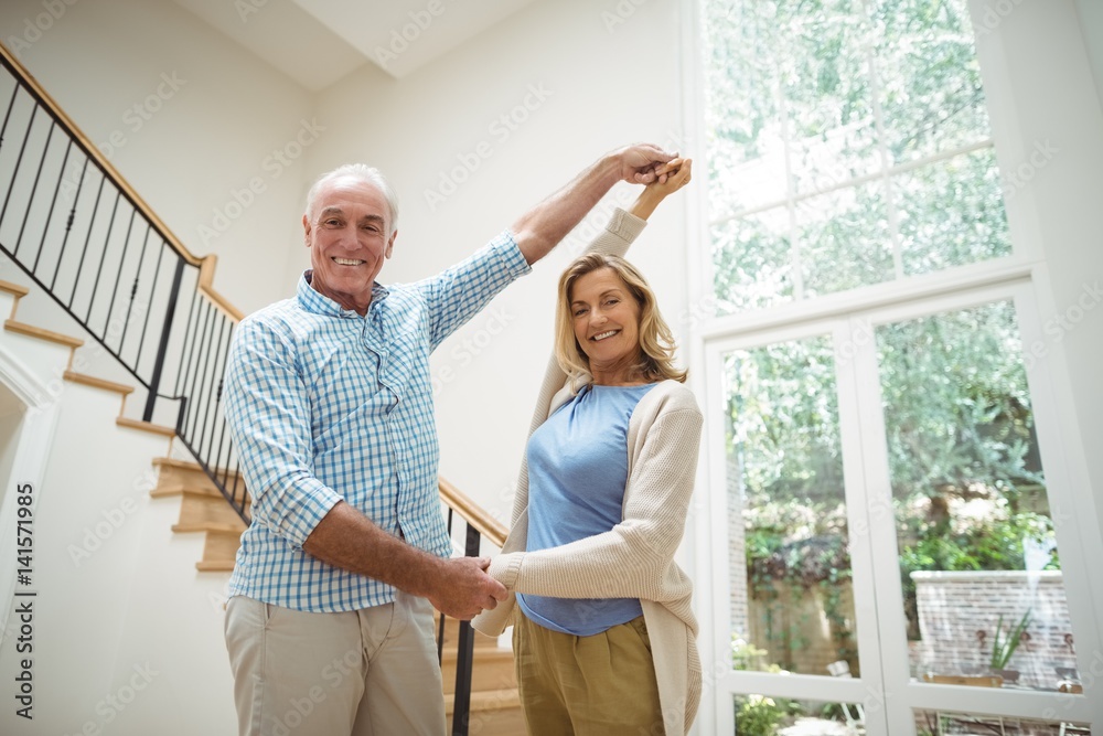 Senior couple dancing together in living room Senior couple dancing together in living room
