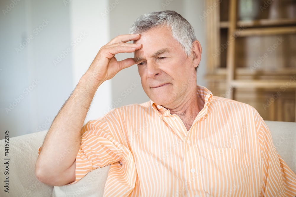 Tense senior man sitting on sofa in living room Tense senior man sitting on sofa in living room