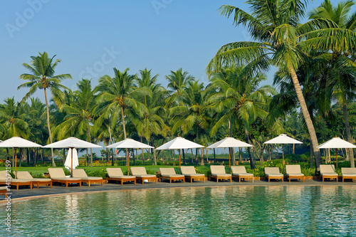 Fototapeta Naklejka Na Ścianę i Meble -  Luxury tropical resort with lounge chairs and umbrella. Goa, India