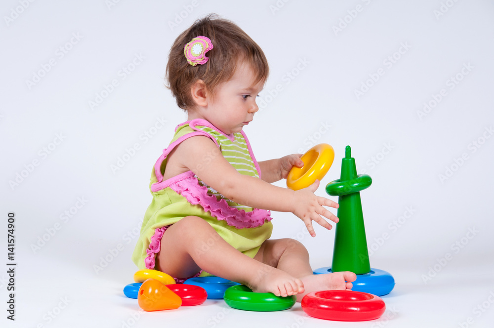 Cute little girl collects a toy pyramid. Cute little girl collects a toy pyramid.